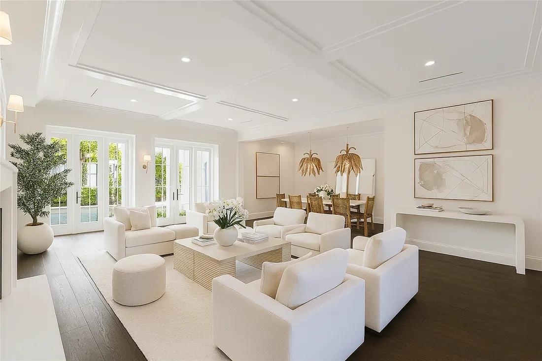 Bright, newly finished living room with white furniture and French doors